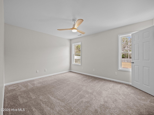 unfurnished room featuring a ceiling fan, carpet, visible vents, and baseboards