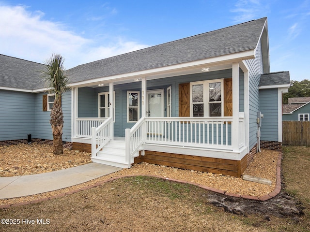 single story home with a shingled roof, fence, and a porch