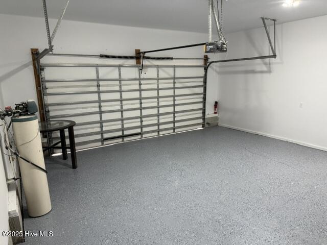 garage featuring a garage door opener and baseboards