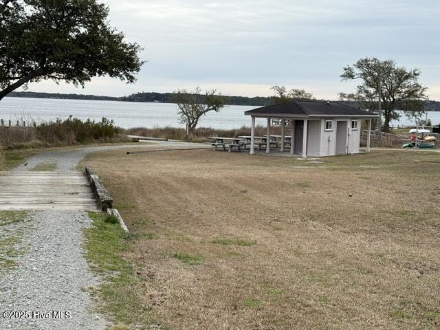 exterior space with an outbuilding, a water view, and driveway