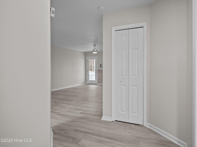 hall featuring light wood-style floors and baseboards