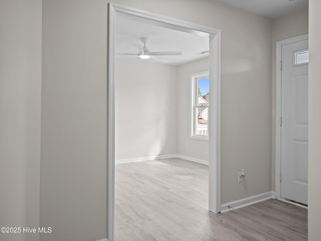 foyer entrance featuring visible vents, ceiling fan, baseboards, and wood finished floors