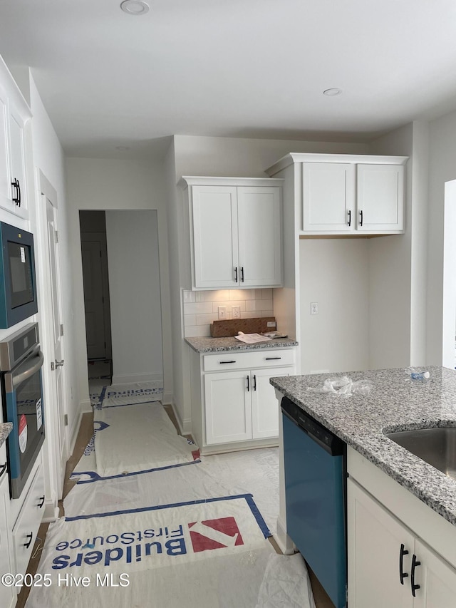 516 Belcroft Dr, Carthage, NC 28327 - kitchen featuring dishwashing machine, oven, built in microwave, light stone countertops, and white cabinetry