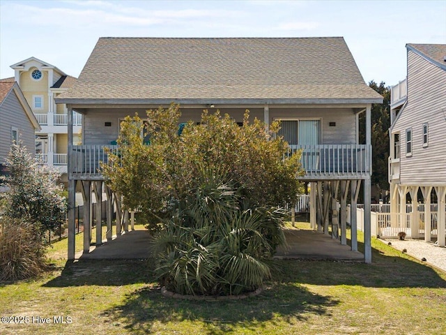 back of house featuring fence, a yard, a shingled roof, a carport, and a patio area