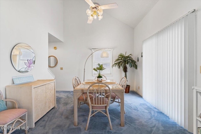 carpeted dining area featuring baseboards, a ceiling fan, and high vaulted ceiling