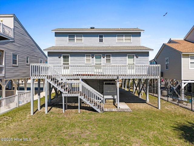 rear view of property with a carport, stairway, a lawn, and fence