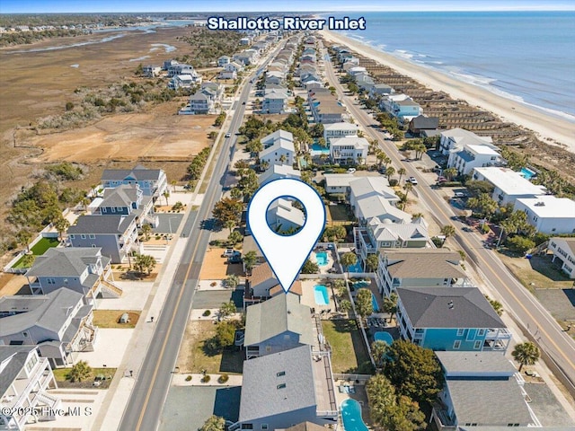 drone / aerial view featuring a residential view, a beach view, and a water view