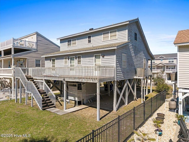 rear view of property featuring stairway, a wooden deck, a yard, and fence