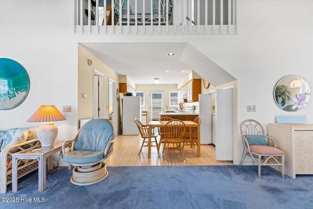 dining room featuring light carpet and a high ceiling