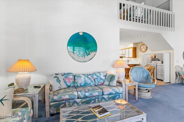 living area with carpet, washing machine and dryer, and a towering ceiling