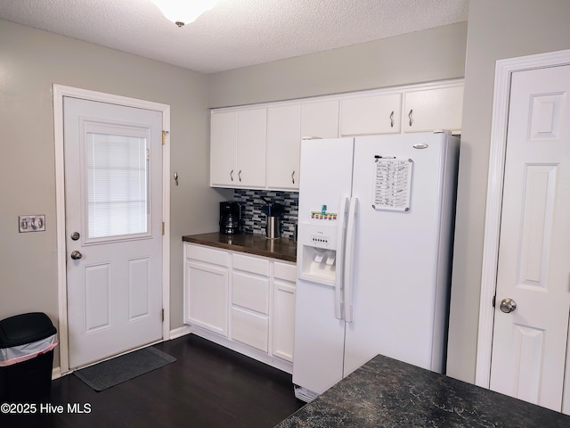 kitchen featuring dark wood-style floors, white refrigerator with ice dispenser, white cabinetry, and backsplash