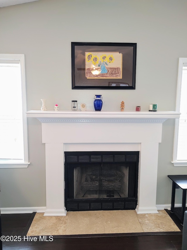 interior details with a fireplace with flush hearth and baseboards