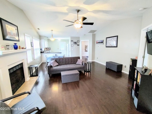 living area featuring dark wood-type flooring, lofted ceiling, and a fireplace