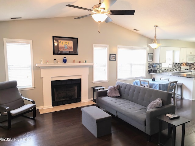 living room with a healthy amount of sunlight, visible vents, and lofted ceiling