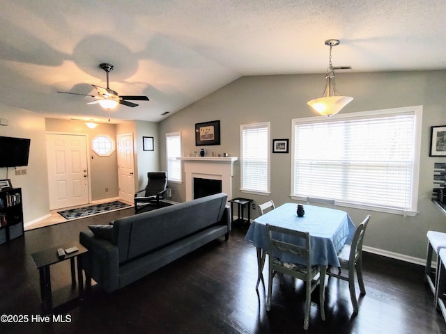 dining area with a fireplace, baseboards, vaulted ceiling, and dark wood-style flooring