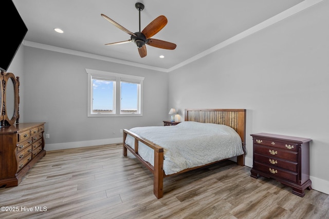 bedroom featuring baseboards, crown molding, and light wood finished floors
