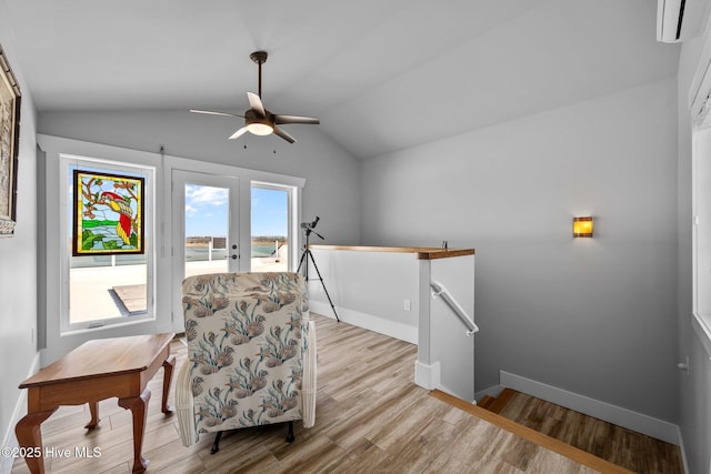 living area with an upstairs landing, baseboards, ceiling fan, wood finished floors, and lofted ceiling