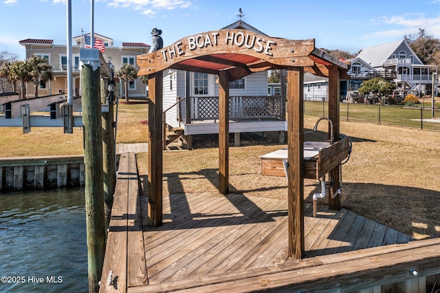 dock area with a water view and a lawn