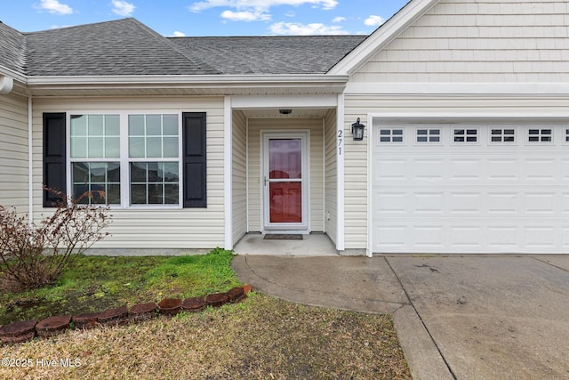 property entrance featuring concrete driveway, a shingled roof, and an attached garage