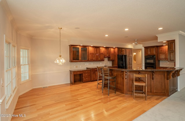 234 Crooked Gulley Cir, Sunset Beach, NC 28468 - kitchen with black appliances, a breakfast bar area, ornamental molding, recessed lighting, and backsplash