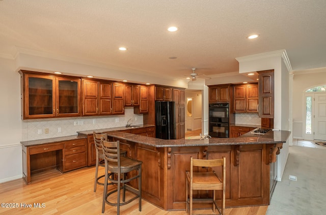 234 Crooked Gulley Cir, Sunset Beach, NC 28468 - kitchen with crown molding, black appliances, a sink, a kitchen breakfast bar, and ceiling fan