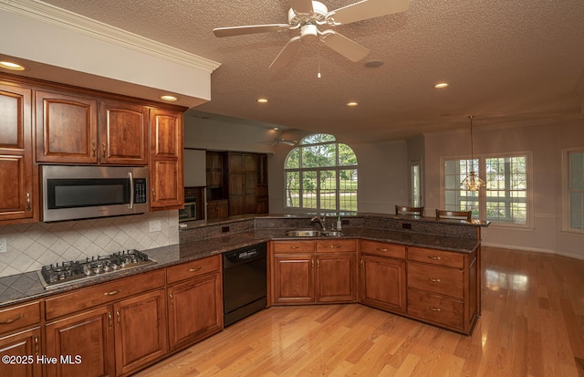 234 Crooked Gulley Cir, Sunset Beach, NC 28468 - kitchen featuring appliances with stainless steel finishes, a ceiling fan, a sink, a textured ceiling, and light wood-type flooring