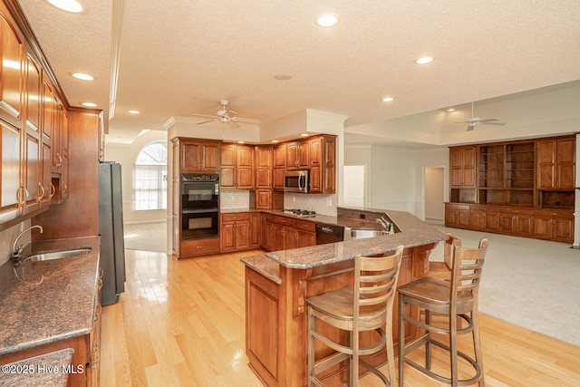 234 Crooked Gulley Cir, Sunset Beach, NC 28468 - kitchen with a ceiling fan, black appliances, a sink, a textured ceiling, and brown cabinetry