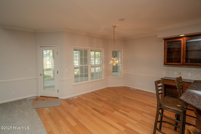 234 Crooked Gulley Cir, Sunset Beach, NC 28468 - unfurnished dining area featuring light wood finished floors, a chandelier, ornamental molding, and baseboards