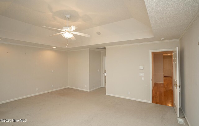 234 Crooked Gulley Cir, Sunset Beach, NC 28468 - unfurnished room with a tray ceiling, ceiling fan, light colored carpet, baseboards, and ornamental molding