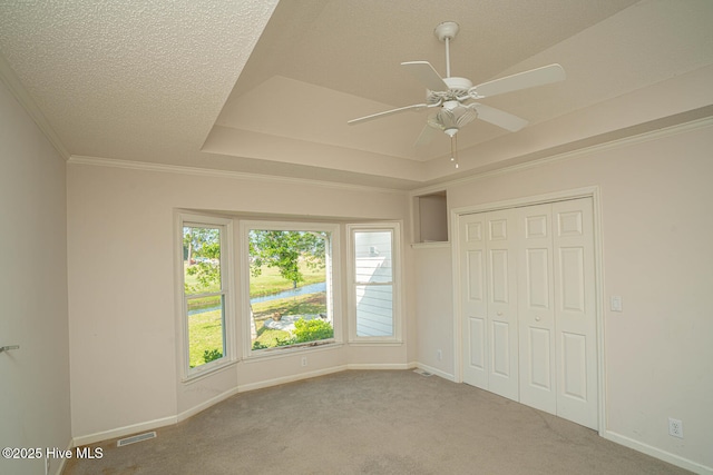 234 Crooked Gulley Cir, Sunset Beach, NC 28468 - unfurnished bedroom featuring carpet flooring, baseboards, a closet, a raised ceiling, and a textured ceiling
