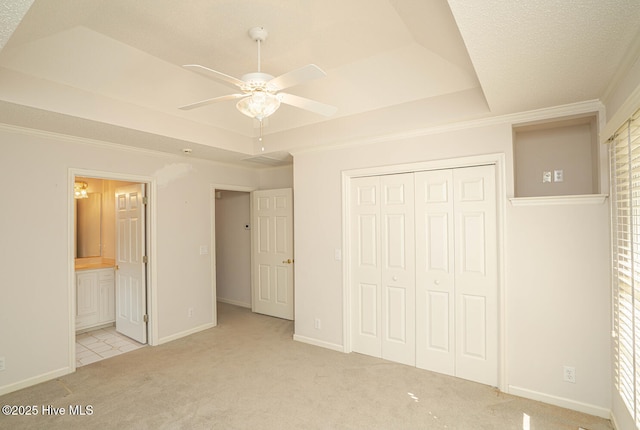 234 Crooked Gulley Cir, Sunset Beach, NC 28468 - unfurnished bedroom with a tray ceiling, carpet, a closet, crown molding, and baseboards