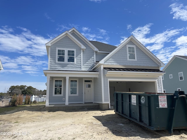 view of front facade with metal roof, a porch, a standing seam roof, and a shingled roof