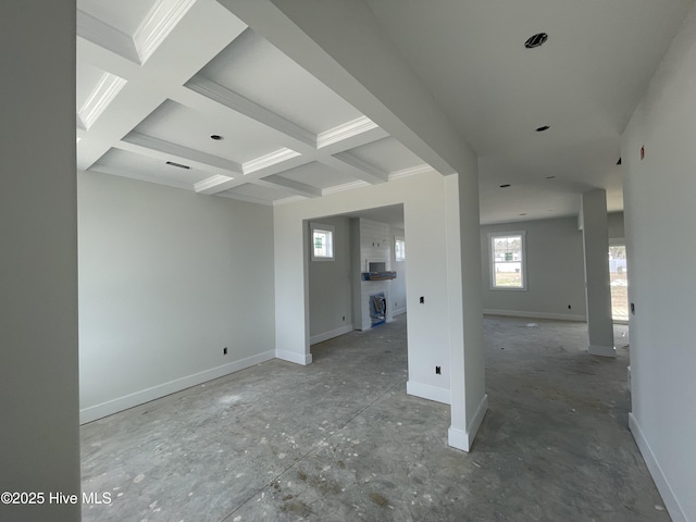 empty room featuring beamed ceiling, coffered ceiling, and baseboards