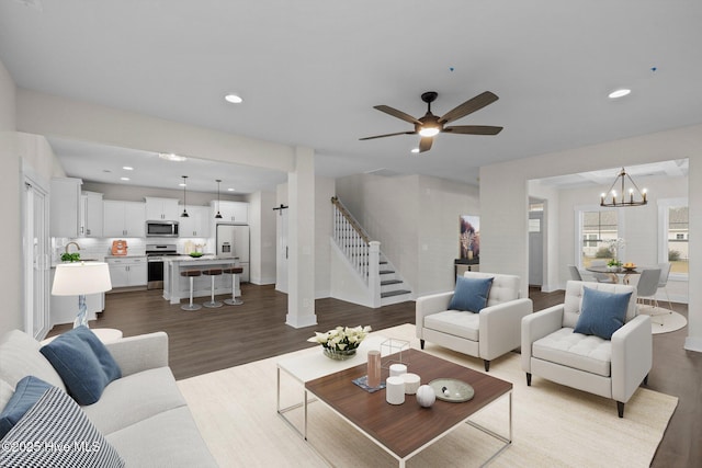 living room featuring recessed lighting, wood finished floors, baseboards, and stairs