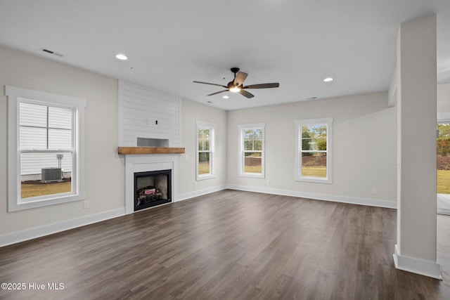 unfurnished living room with baseboards, visible vents, and dark wood-style flooring