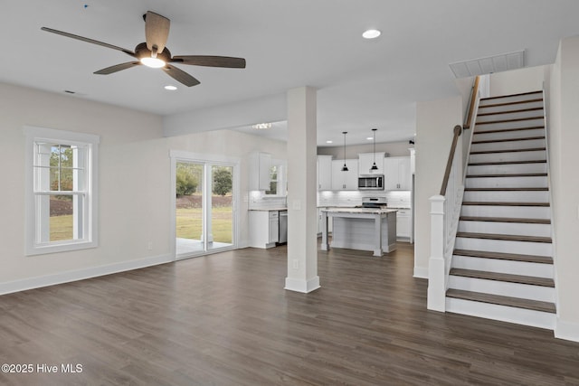 unfurnished living room featuring baseboards, stairway, dark wood-type flooring, and recessed lighting