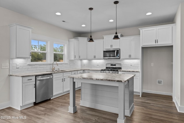 kitchen featuring stainless steel appliances, dark wood-style flooring, white cabinetry, and a sink