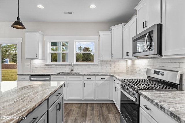 kitchen featuring stainless steel appliances, tasteful backsplash, a sink, and a healthy amount of sunlight