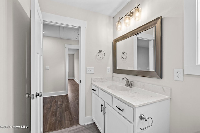 bathroom with vanity, baseboards, and wood finished floors