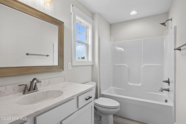 bathroom featuring wood finished floors, vanity, toilet, and shower / bathtub combination