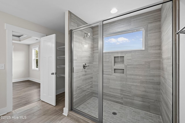 bathroom with a shower stall, baseboards, and wood finished floors