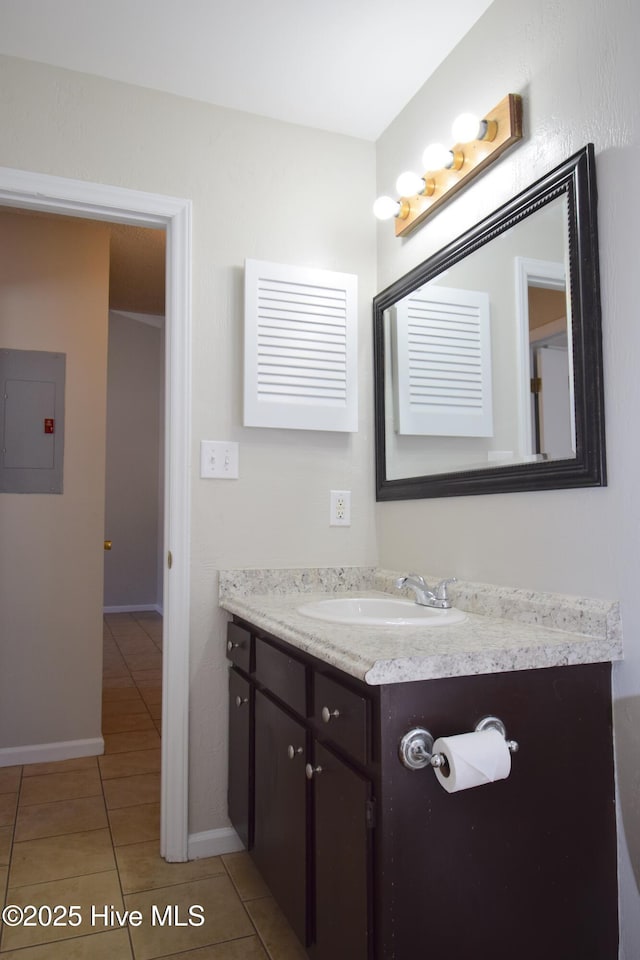 bathroom featuring vanity, tile patterned flooring, electric panel, and baseboards