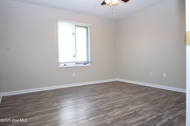 unfurnished room featuring dark wood-type flooring, a ceiling fan, and baseboards