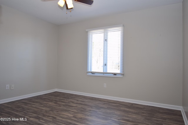 empty room with dark wood finished floors, ceiling fan, and baseboards