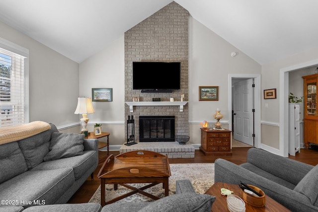 living area featuring high vaulted ceiling, a brick fireplace, wood finished floors, and baseboards