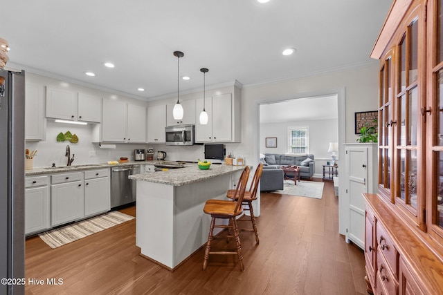 kitchen with dark wood-style flooring, appliances with stainless steel finishes, white cabinets, and a sink