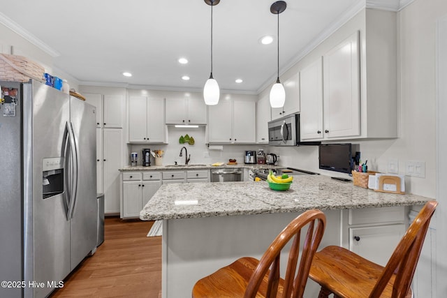 kitchen featuring ornamental molding, a peninsula, appliances with stainless steel finishes, and white cabinets