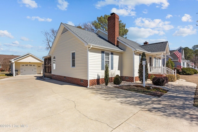 view of property exterior with crawl space, a detached garage, a chimney, and an outbuilding