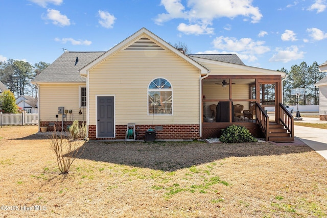 view of front of property with a front lawn, crawl space, fence, and a sunroom