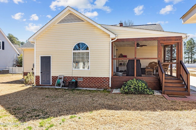 view of front facade with a sunroom, fence, and a front lawn